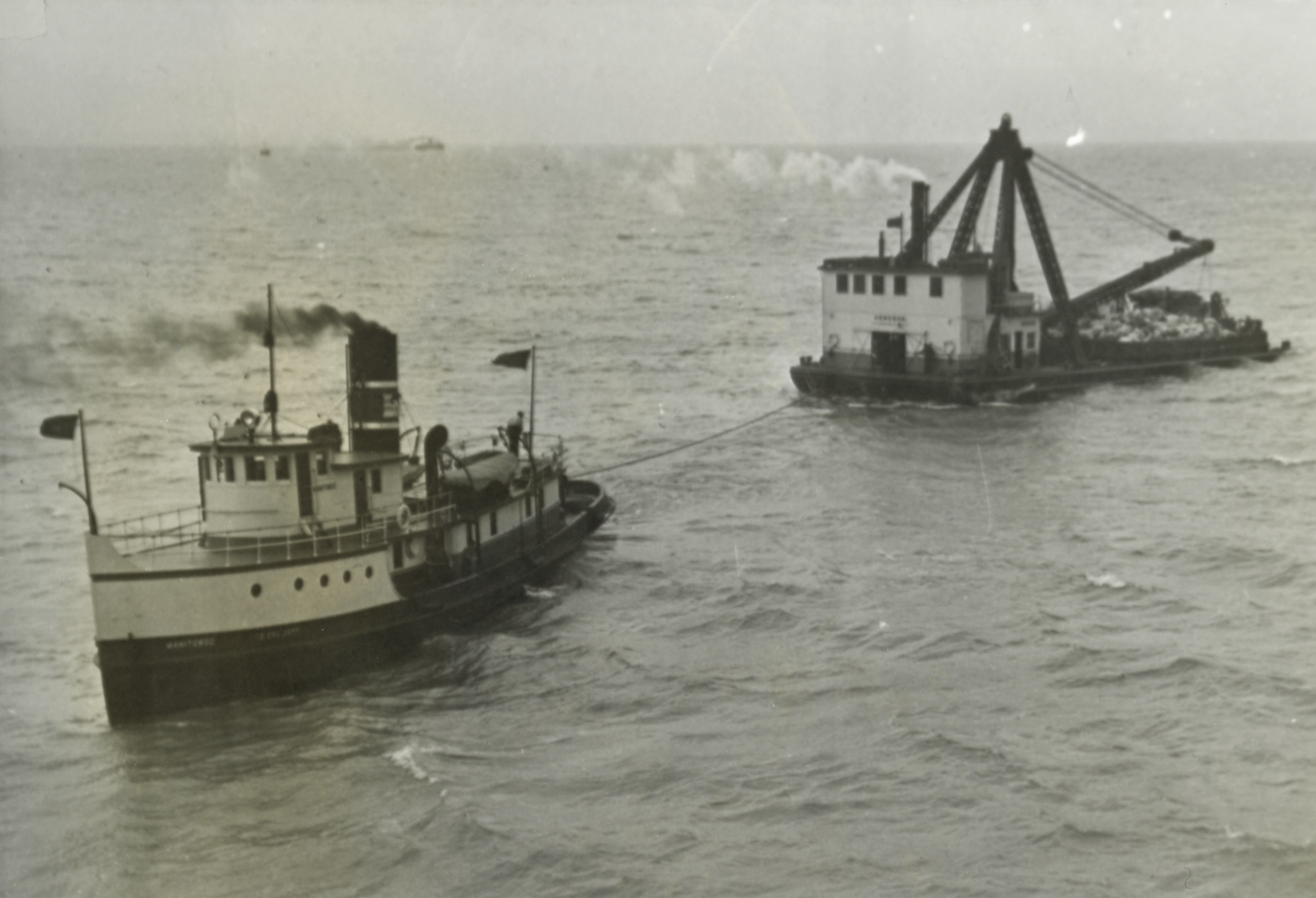 black and white photograph of two small ships near each other and angled in the water black and white photograph of two small ships near each other and angled in the water